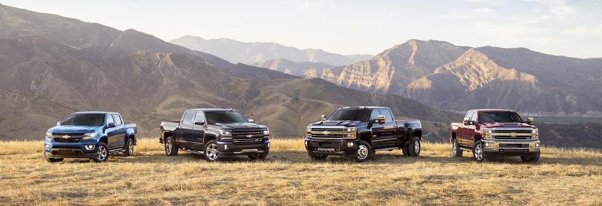 Chevrolet trucks parked in front of mountains